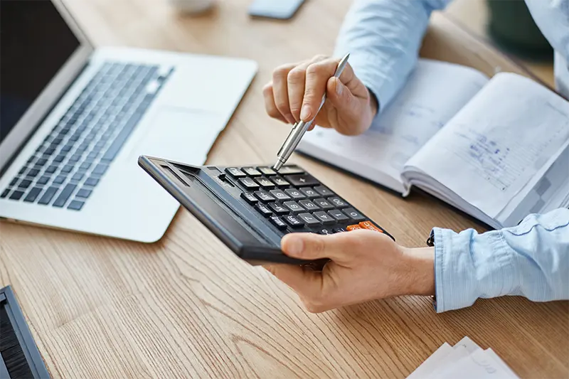 cropped view professional serious finance manager holding calculator hands checking company month s profits 1